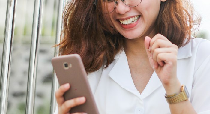 Cliente sorrindo olhando o celular