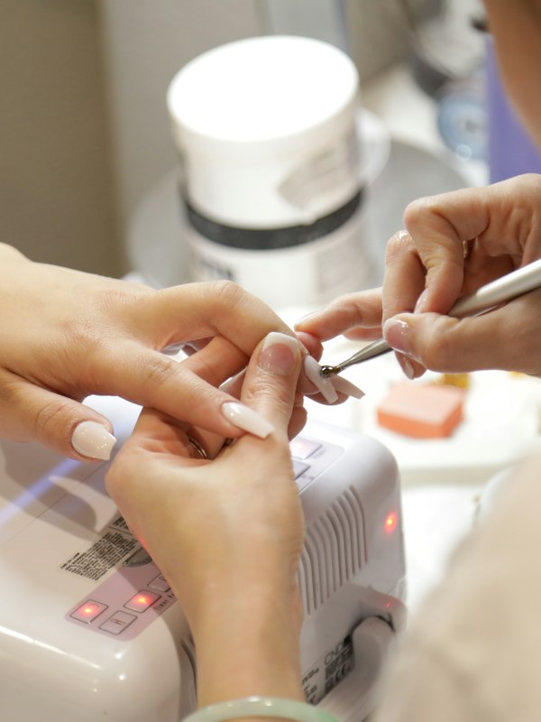 Manicure fazendo as unhas de uma cliente